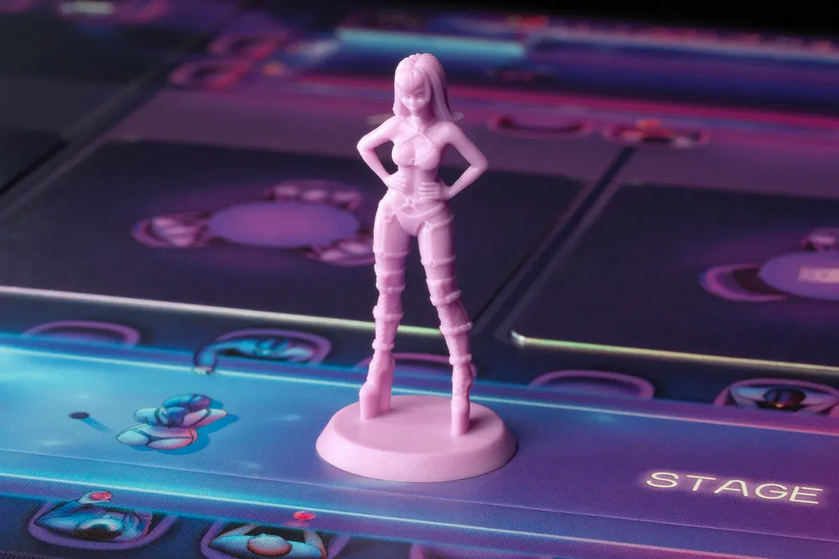 An image of a playing piece for the board game 'Nightshift', created by Exotic Cancer. The playing piece is pale pink and in the shape of a dancer.